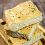 Focaccia is an Italian flat bread similar to the crust of Sicilian pizza. It is moist, chewy, and topped with savory rosemary.