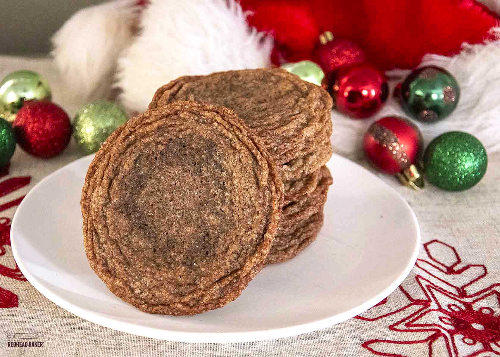 A stack of caramel nutella crisps on a white plate in front of a Santa hat. 