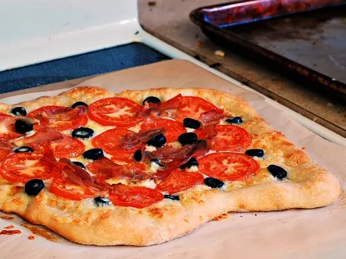 Pizza with Fontina, Tomatoes, Olives, and Prosciutto