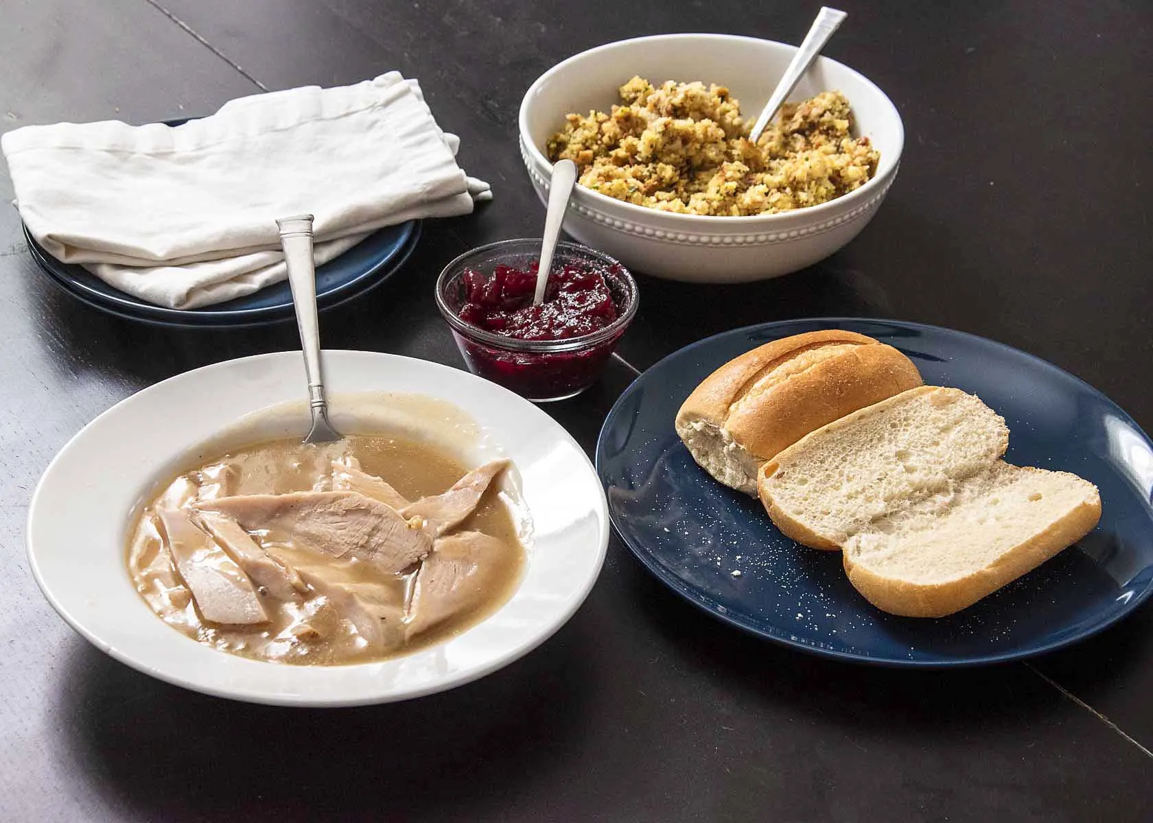 Ingredients for a Thanksgiving leftovers sandwich: turkey, gravy, cranberry sauce, stuffing and club rolls.