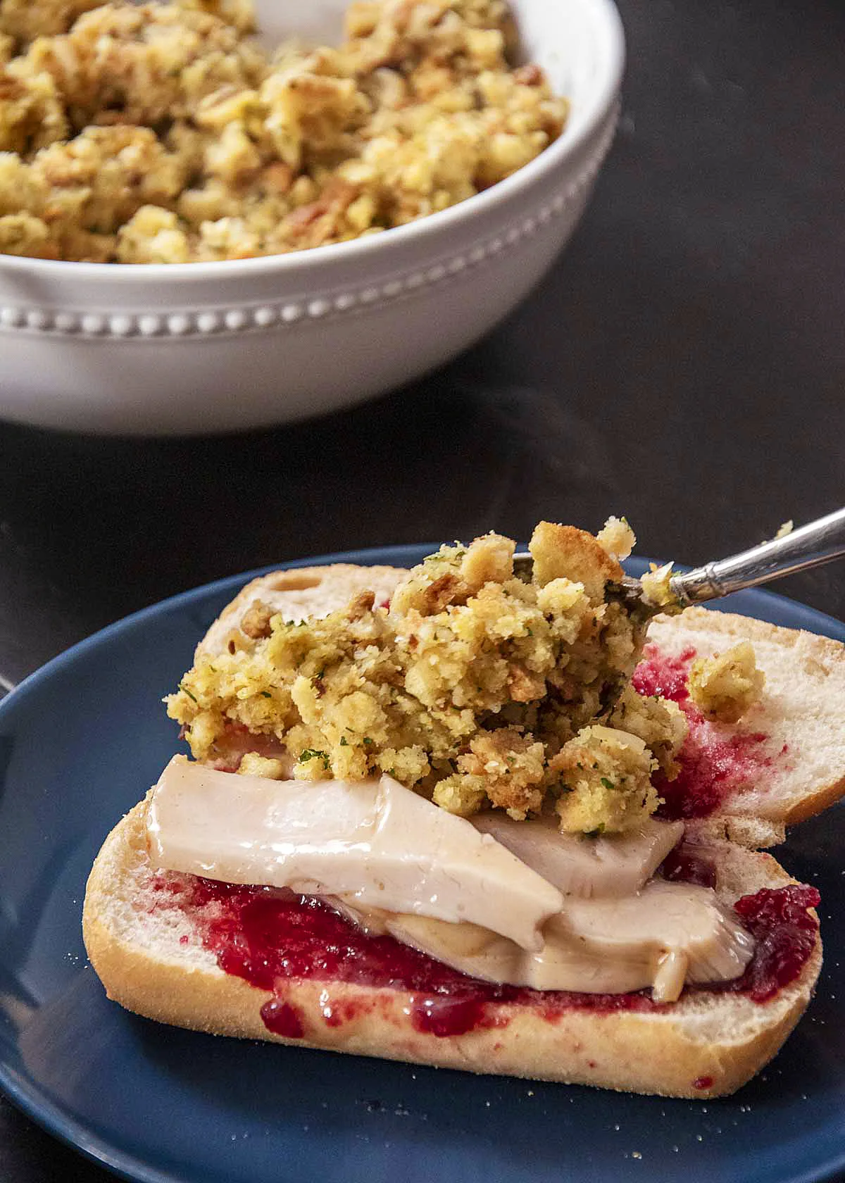 Adding stuffing to the Thanksgiving leftover sandwich.