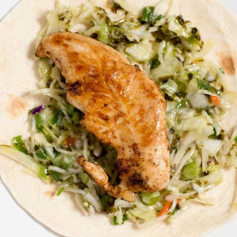 Chicken tacos are spiced with ancho chile powder and topped with cilantro slaw and avocado cream. This delicious meal is ready in under 30 minutes!