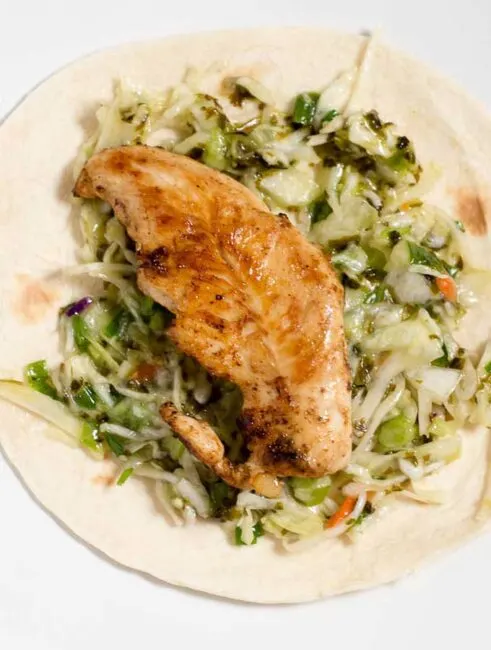 Chicken tacos are spiced with ancho chile powder and topped with cilantro slaw and avocado cream. This delicious meal is ready in under 30 minutes!