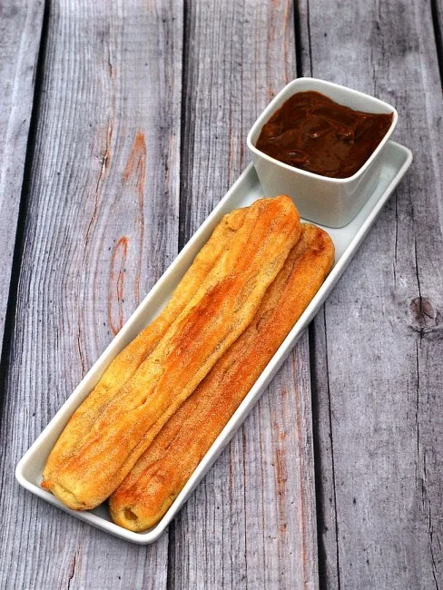 Snack on baked churros dipped in dulce de leche this Cinco de Mayo! | theredheadbaker.com