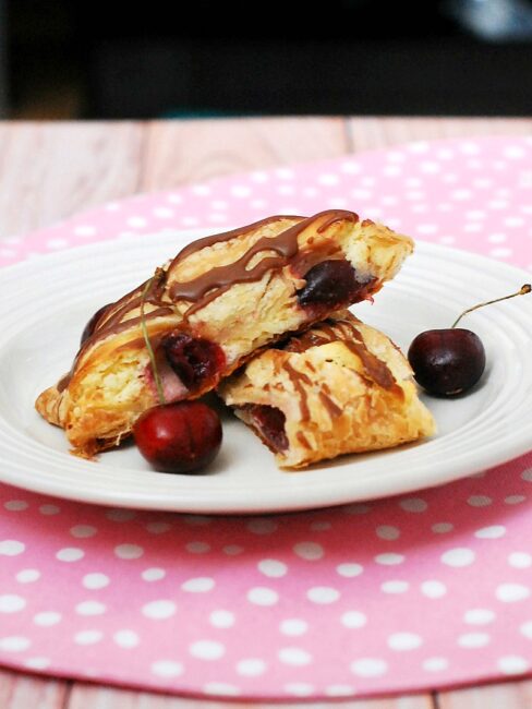 Honor the mothers in your life with this beautiful, decadent cherry cheesecake pastry braid drizzled with chocolate glaze. #SundaySupper theredheadbaker.com