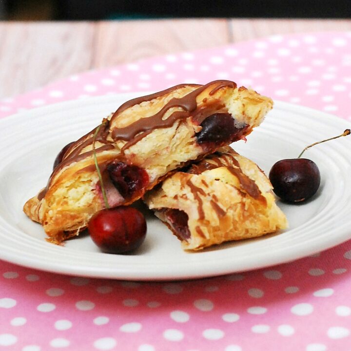 Honor the mothers in your life with this beautiful, decadent cherry cheesecake pastry braid drizzled with chocolate glaze. #SundaySupper theredheadbaker.com