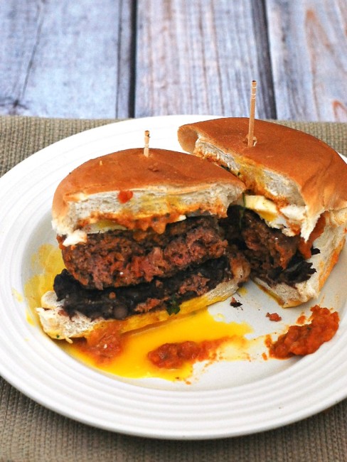 Add a kick to your brunch with huevos rancheros burgers! Spicy chorizo and beef burgers are topped with a poached egg and spicy huevos rancheros sauce. #BrunchWeek theredheadbaker.com