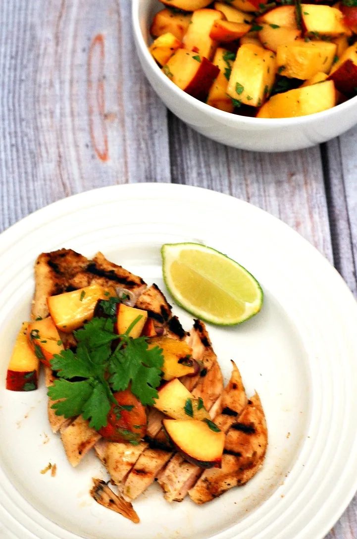 Grilled peach salsa adds a smoky sweet flavor to spiced chicken breasts. Use thin-sliced chicken breasts to cut down on cooking time. #CLBlogger