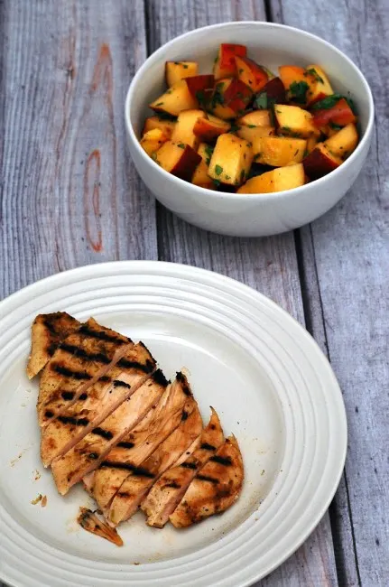 Grilled peach salsa adds a smoky sweet flavor to spiced chicken breasts. Use thin-sliced chicken breasts to cut down on cooking time. #CLBlogger