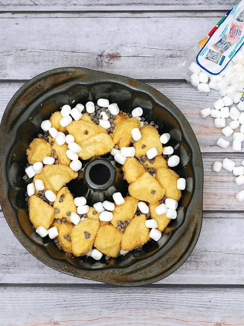 Nothing says summer snack likes s'mores monkey bread! Little balls of sweet bread are coated in graham cracker crumbs and baked with layers of chocolate and marshmallow. #TwelveLoaves theredheadbaker.com