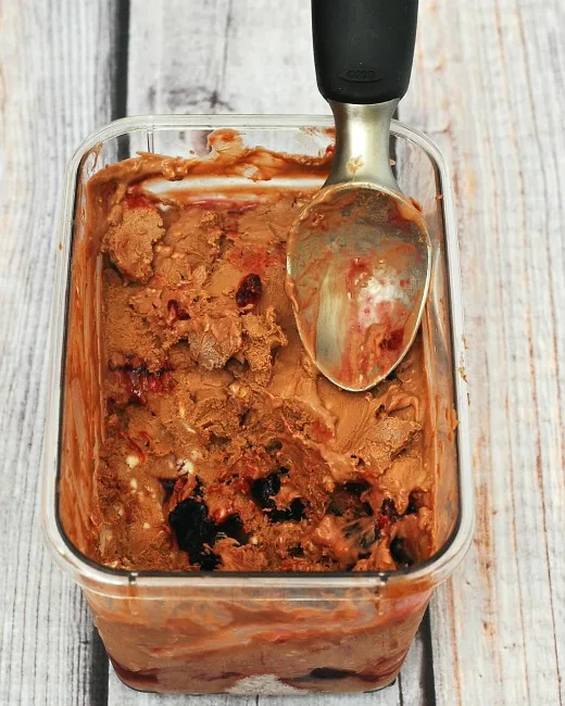 Rich chocolate cheesecake ice cream with swirls of roasted cherries with a hint of vanilla &mdash; it's easy to make but so hard to stop eating! theredheadbaker.com