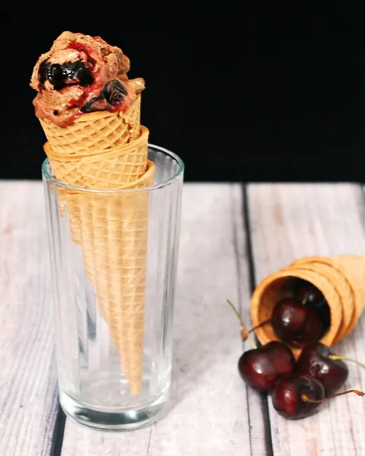 Rich chocolate cheesecake ice cream with swirls of roasted cherries with a hint of vanilla &mdash; it's easy to make but so hard to stop eating! theredheadbaker.com
