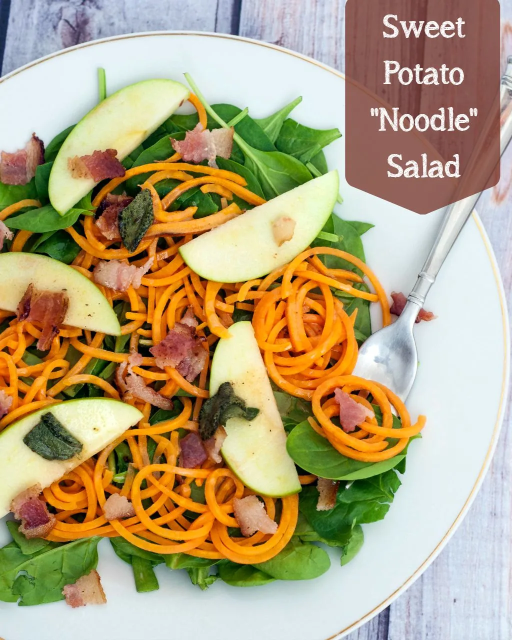 Sweet potato noodle salad swaps spiralized sweet potatos for pasta, served over spinach and apples with a delicious and tangy warm sage-brown-butter dressing. TheRedheadBaker.com