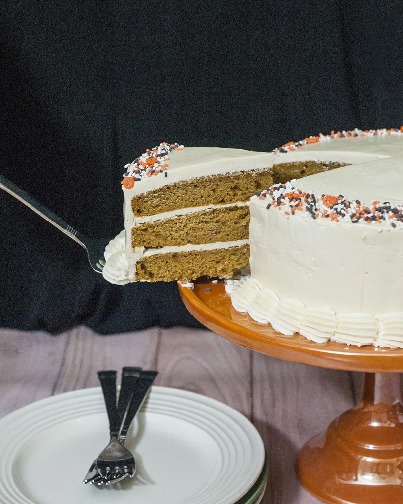 Pumpkin Cake with Salted Caramel Icing is a decadent fall treat. Three layers of moist pumpkin cake is layered with satin-smooth salted caramel Swiss buttercream. #PumpkinWeek