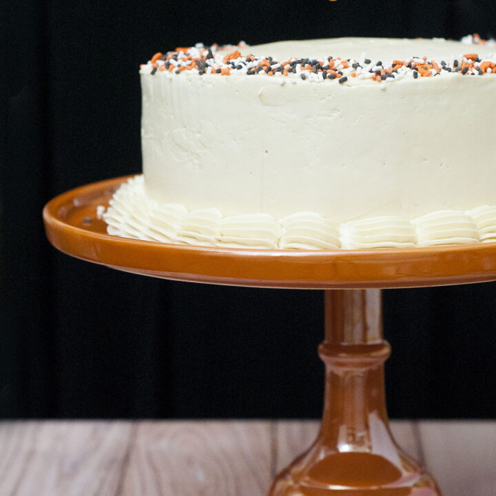 Pumpkin Cake with Salted Caramel Icing is a decadent fall treat. Three layers of moist pumpkin cake is layered with satin-smooth salted caramel Swiss buttercream. #PumpkinWeek