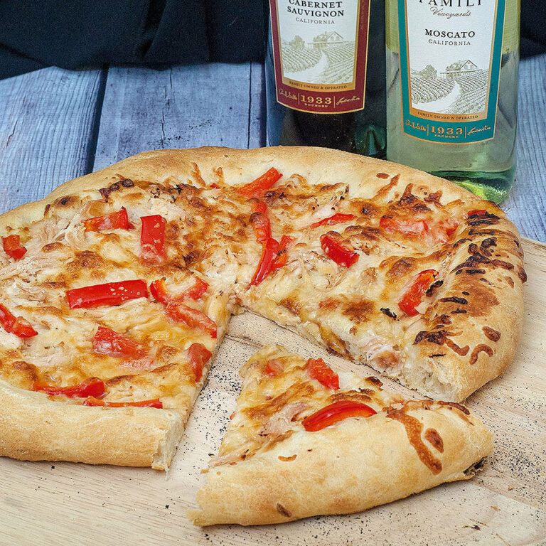 Make an exotic Thai chicken pizza for National Pizza month! Top homemade a pizza crust with sweet Thai sweet chili sauce, shredded chicken and bell peppers. #SundaySupper TheRedheadBaker.com