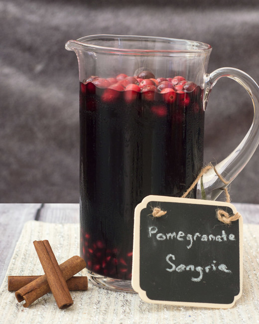 Pomegranate sangria combines fruity red wine with pomegranate and cranberry, with cinnamon for a hint of spice. Make a large batch a day ahead for a winning party cocktail! #SundaySupper TheRedheadBaker.com