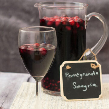 Pomegranate sangria combines fruity red wine with pomegranate and cranberry, with cinnamon for a hint of spice. Make a large batch a day ahead for a winning party cocktail! #SundaySupper TheRedheadBaker.com