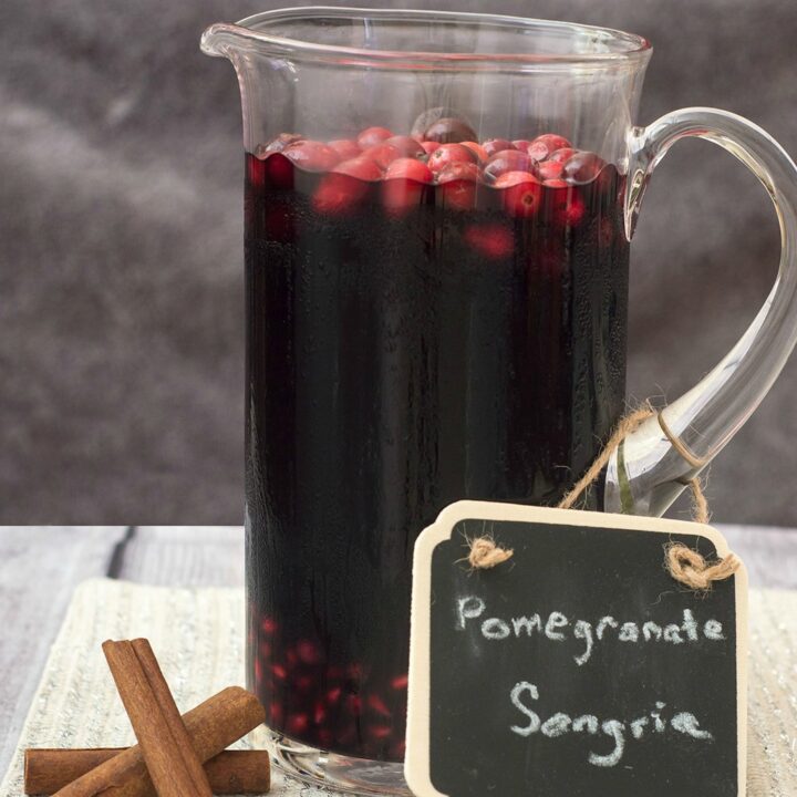 Pomegranate sangria combines fruity red wine with pomegranate and cranberry, with cinnamon for a hint of spice. Make a large batch a day ahead for a winning party cocktail! #SundaySupper TheRedheadBaker.com