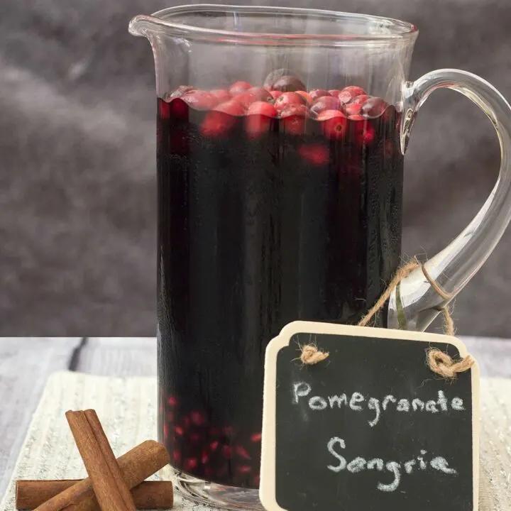 Pomegranate sangria combines fruity red wine with pomegranate and cranberry, with cinnamon for a hint of spice. Make a large batch a day ahead for a winning party cocktail! #SundaySupper TheRedheadBaker.com