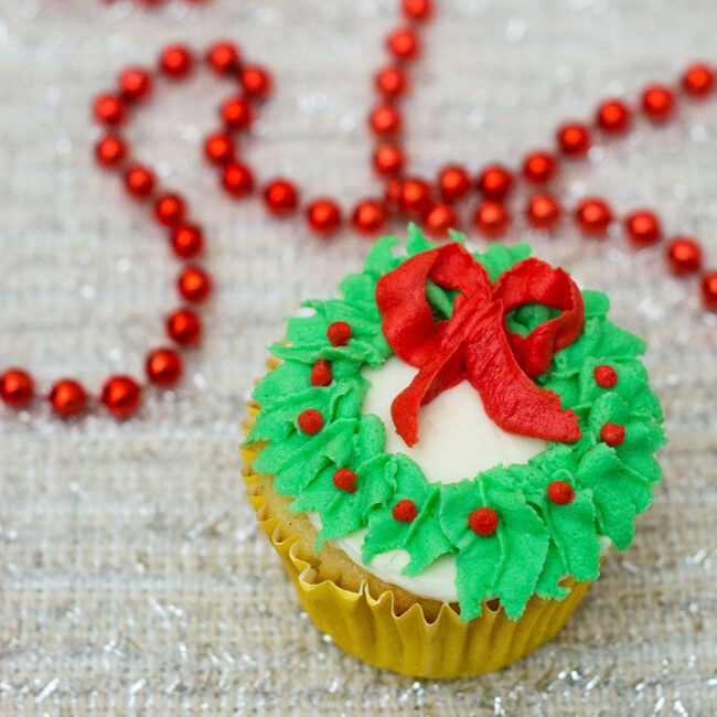 In this Christmas Wreath Cupcake tutorial, I show you how to turn your favorite cupcake into a festive Christmas wreath with some red and green icing and a few simple tools.