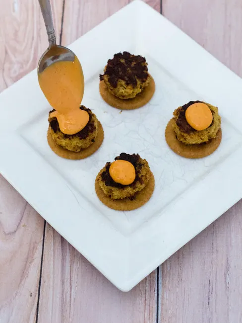 Bring some heat to your bowl game party with mini crab cakes served on RITZ&reg; crackers, topped with spicy sriracha aioli. TheRedheadBaker.com #BowlTimeSnacks #ad