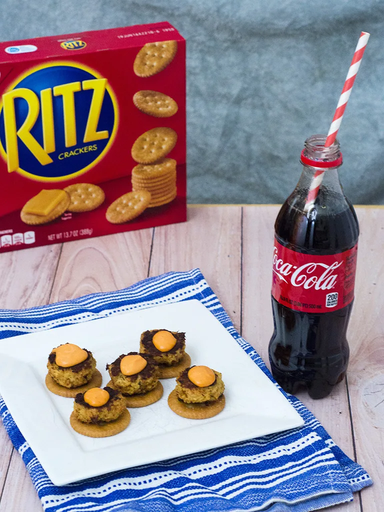 Bring some heat to your bowl game party with mini crab cakes served on RITZ® crackers, topped with spicy sriracha aioli. TheRedheadBaker.com #BowlTimeSnacks #ad