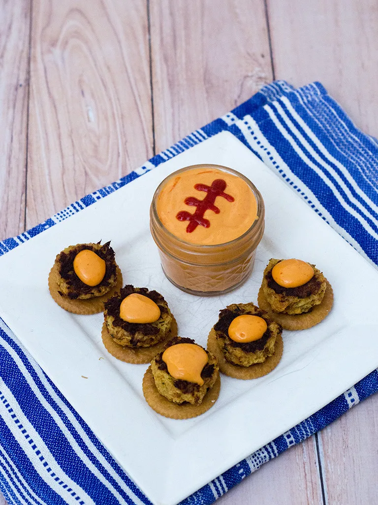 Bring some heat to your bowl game party with mini crab cakes served on RITZ® crackers, topped with spicy sriracha aioli. TheRedheadBaker.com #BowlTimeSnacks #ad