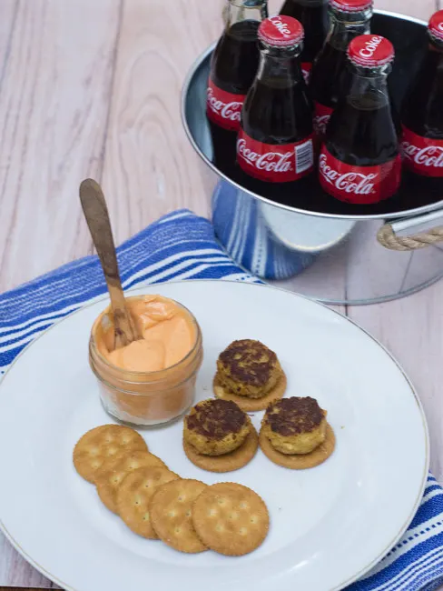 Bring some heat to your bowl game party with mini crab cakes served on RITZ&reg; crackers, topped with spicy sriracha aioli. TheRedheadBaker.com #BowlTimeSnacks #ad