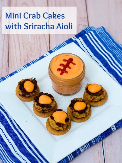 Bring some heat to your bowl game party with mini crab cakes served on RITZ&reg; crackers, topped with spicy sriracha aioli. TheRedheadBaker.com #BowlTimeSnacks #ad
