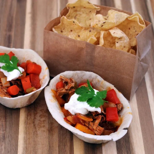 Spice up your Game Day tailgate snacks with these Carnitas Chili Bowls, flavored with Old El Paso&trade; seasoning and salsa, served in soft tortilla bowls. #oldelpaso #acmemarkets