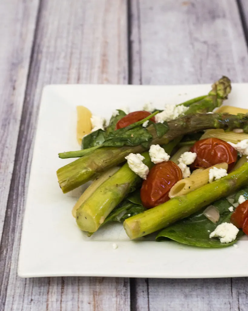 This versatile pasta salad combines roasted asparagus and tomatoes with penne and spinach, dressed in a low-calorie lemon vinaigrette. #CLBlogger TheRedheadBaker.com