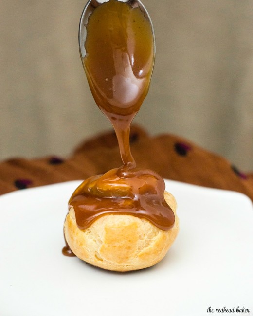 Sweet cream puffs are filled with salted caramel pastry cream, then topped with rich chocolate ganache. Finger food for dessert! #SundaySupper TheRedheadBaker.com