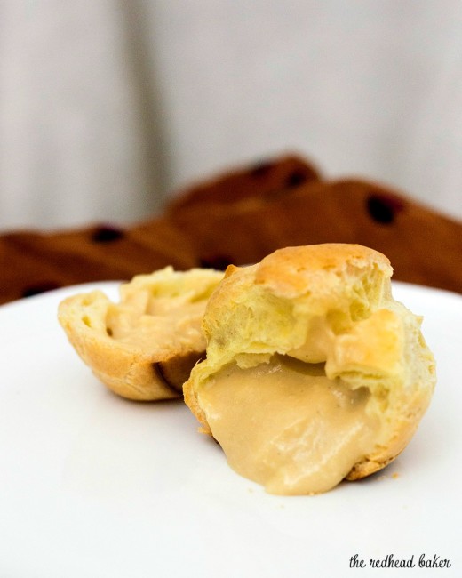 Sweet cream puffs are filled with salted caramel pastry cream, then topped with rich chocolate ganache. Finger food for dessert! #SundaySupper TheRedheadBaker.com