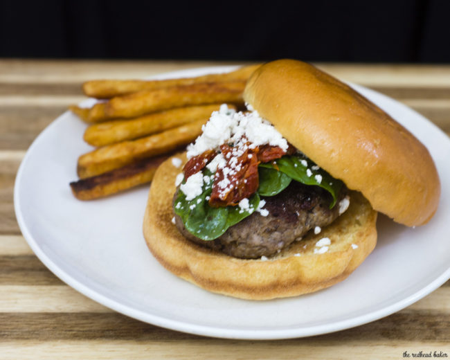 Lamb burgers are flavored with herbs and spices of Greece, then topped with spinach and sun-dried tomatoes tossed with lemon, and a sprinkle of feta. TheRedheadBaker.com