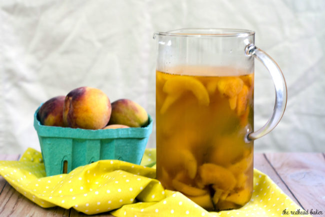 If you try one new cocktail this summer, make it this peach vanilla sangria. Crisp white wine is flavored with peaches, brandy and syrup infused with vanilla bean. #TheRedheadBaker