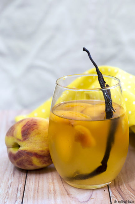 If you try one new cocktail this summer, make it this peach vanilla sangria. Crisp white wine is flavored with peaches, brandy and syrup infused with vanilla bean. #TheRedheadBaker