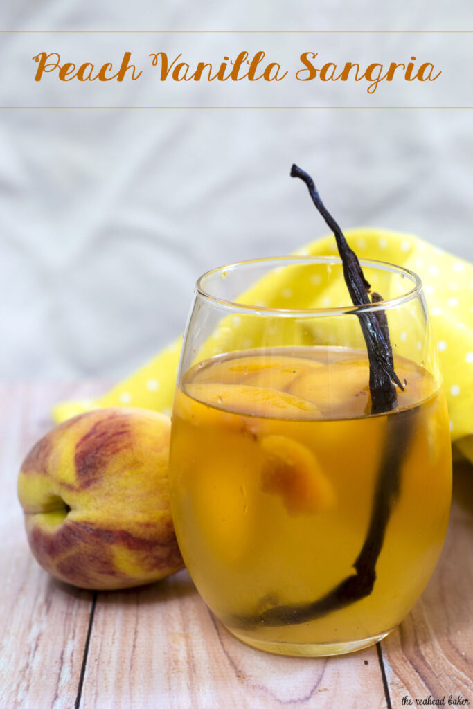 If you try one new cocktail this summer, make it this peach vanilla sangria. Crisp white wine is flavored with peaches, brandy and syrup infused with vanilla bean. #TheRedheadBaker