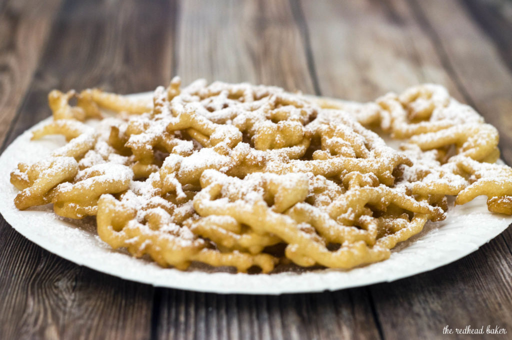 Boardwalk funnel cake takes me back to childhood vacations at a New Jersey beach. This warm deep-fried treat is dusted with powdered sugar and great for sharing! #SundaySupper TheRedheadBaker.com