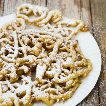 Boardwalk funnel cake takes me back to childhood vacations at a New Jersey beach. This warm deep-fried treat is dusted with powdered sugar and great for sharing! #SundaySupper TheRedheadBaker.com