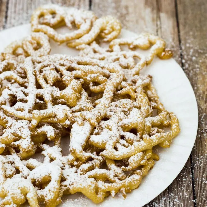 Boardwalk funnel cake takes me back to childhood vacations at a New Jersey beach. This warm deep-fried treat is dusted with powdered sugar and great for sharing! #SundaySupper TheRedheadBaker.com