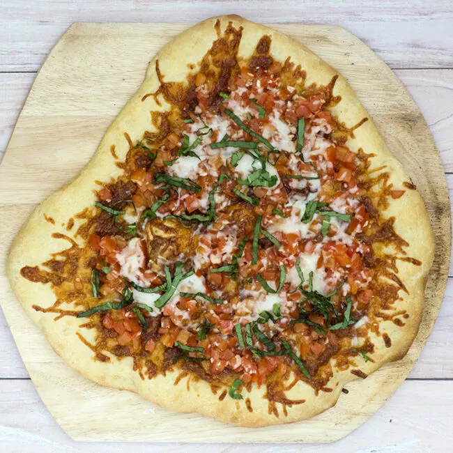 Bruschetta pizza is loaded with fresh summer tomatoes, basil and garlic over lots of melted mozzarella cheese. What better flavor for summer pizza? #ProgressiveEats
