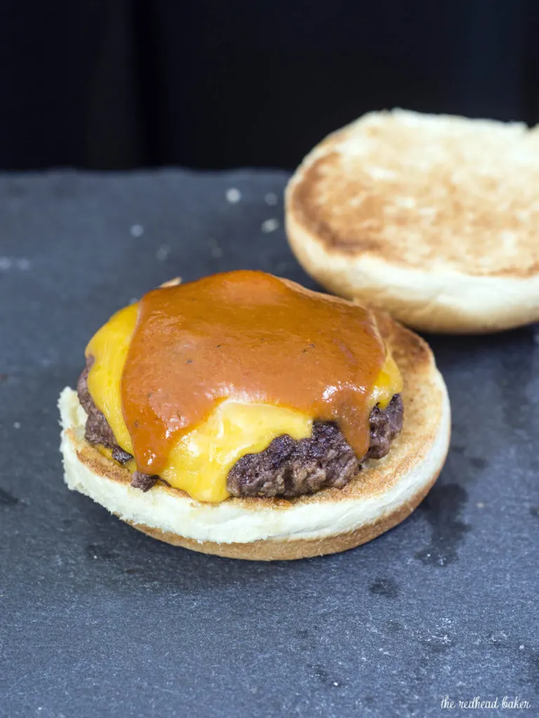 Carolina-style BBQ burgers are juicy beef patties topped with sharp cheddar cheese, tangy mustard- and vinegar-based BBQ sauce and coleslaw. #SundaySupper TheRedheadBaker.com