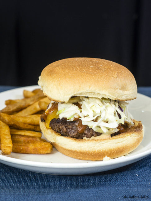 Carolina-style BBQ burgers are juicy beef patties topped with sharp cheddar cheese, tangy mustard- and vinegar-based BBQ sauce and coleslaw. #SundaySupper TheRedheadBaker.com