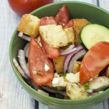 Greek Panzanella Salad is a perfect summer weeknight meal that combines tomato, red onion, cucumber, chicken and toasted bread with a homemade vinaigrette. TheRedheadBaker.com