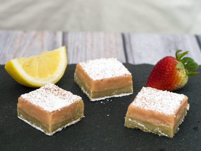 Strawberry lemon bars are a sweet twist on a tart classic bar cookie. These bars bring back memories of childhood summers drinking pink lemonade. #WhatsBaking TheRedheadBaker