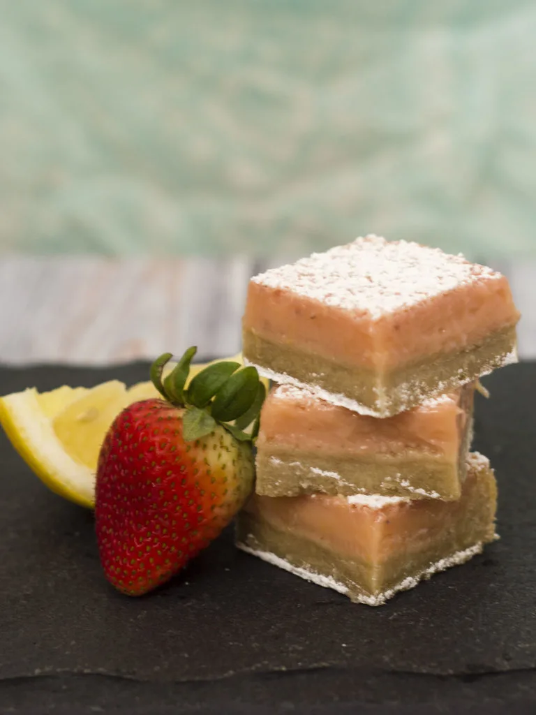 Strawberry lemon bars are a sweet twist on a tart classic bar cookie. These bars bring back memories of childhood summers drinking pink lemonade. #WhatsBaking TheRedheadBaker