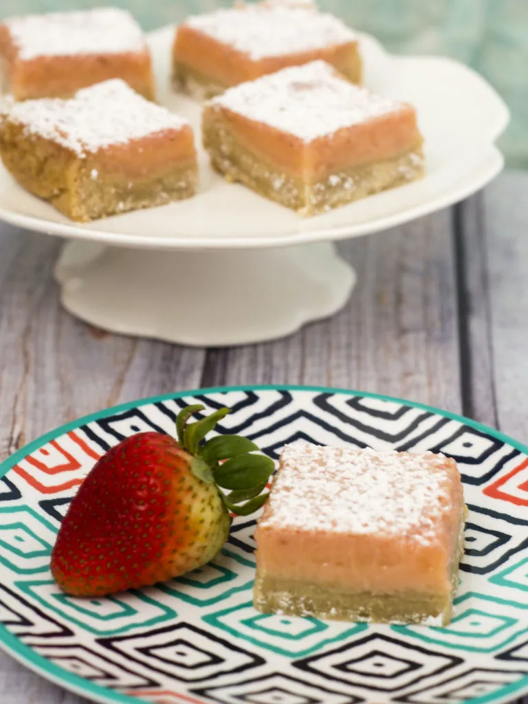 Strawberry lemon bars are a sweet twist on a tart classic bar cookie. These bars bring back memories of childhood summers drinking pink lemonade. #WhatsBaking TheRedheadBaker