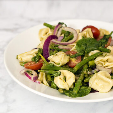 Tomato tortellini salad is my new favorite summer dinner! It combines lots of fresh, healthy vegetables, and comes together in under 30 minutes!