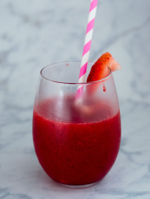 Strawberry sangria slushies are fun frozen cocktail — white wine blends with frozen strawberries and triple sec for a delicious summer treat!